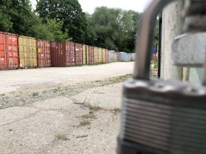 wynajem kontenerów morskich - widoczna kłódka od kontenera i szereg magazynów kontenerowych